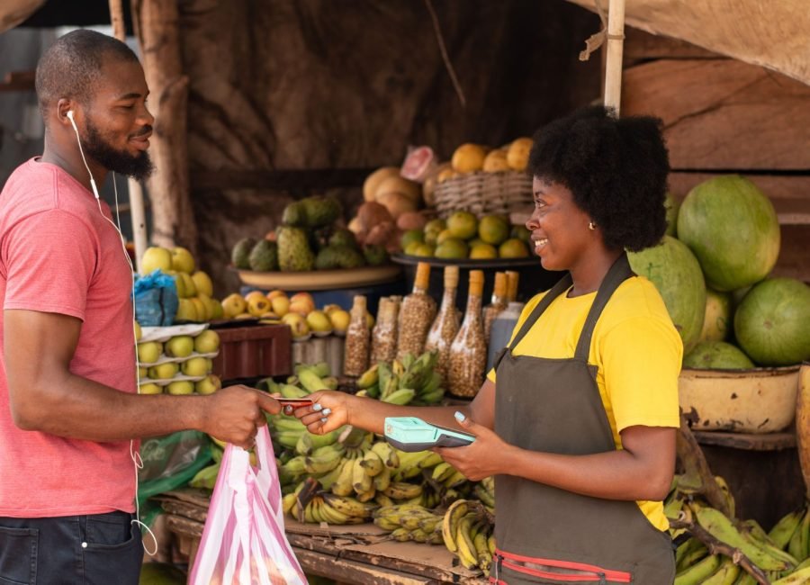 An african farmer shaking hands with a buyer at a fresh produce market